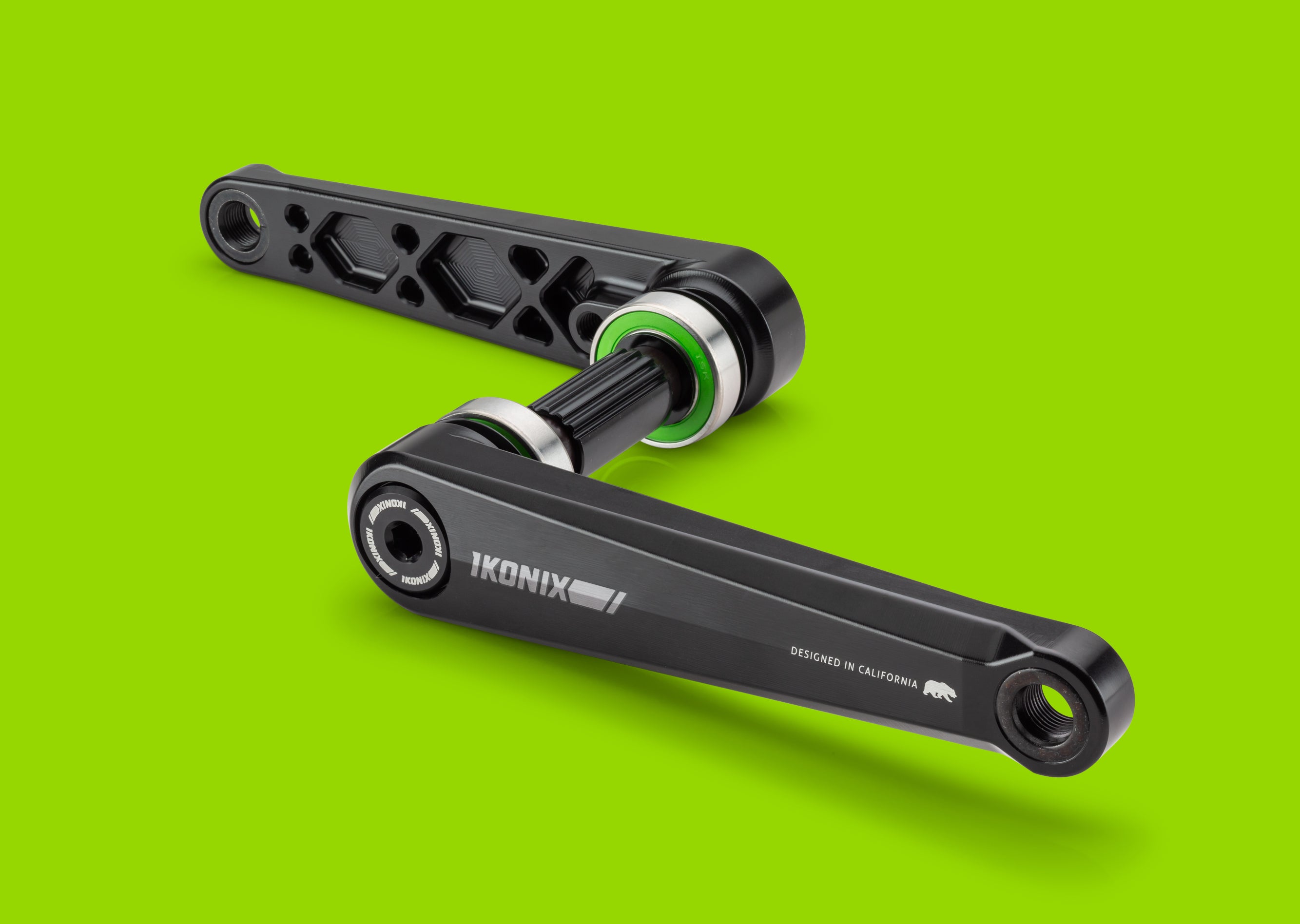 Black bicycle crankset with 'IKONIX' branding on a green background